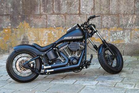 Черный мотоцикл Harley-Davidson на фоне кирпичной стены