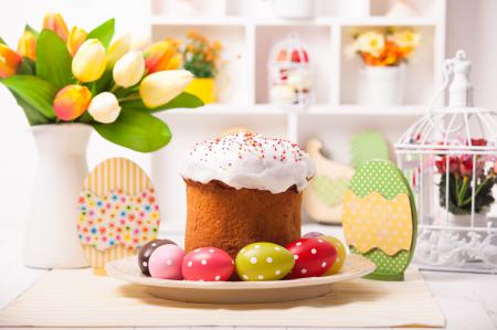 Пасхальный пирог с яйцами и букетом цветов на столе