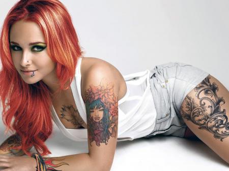 Рыжая девушка с пирсингом и татуировками